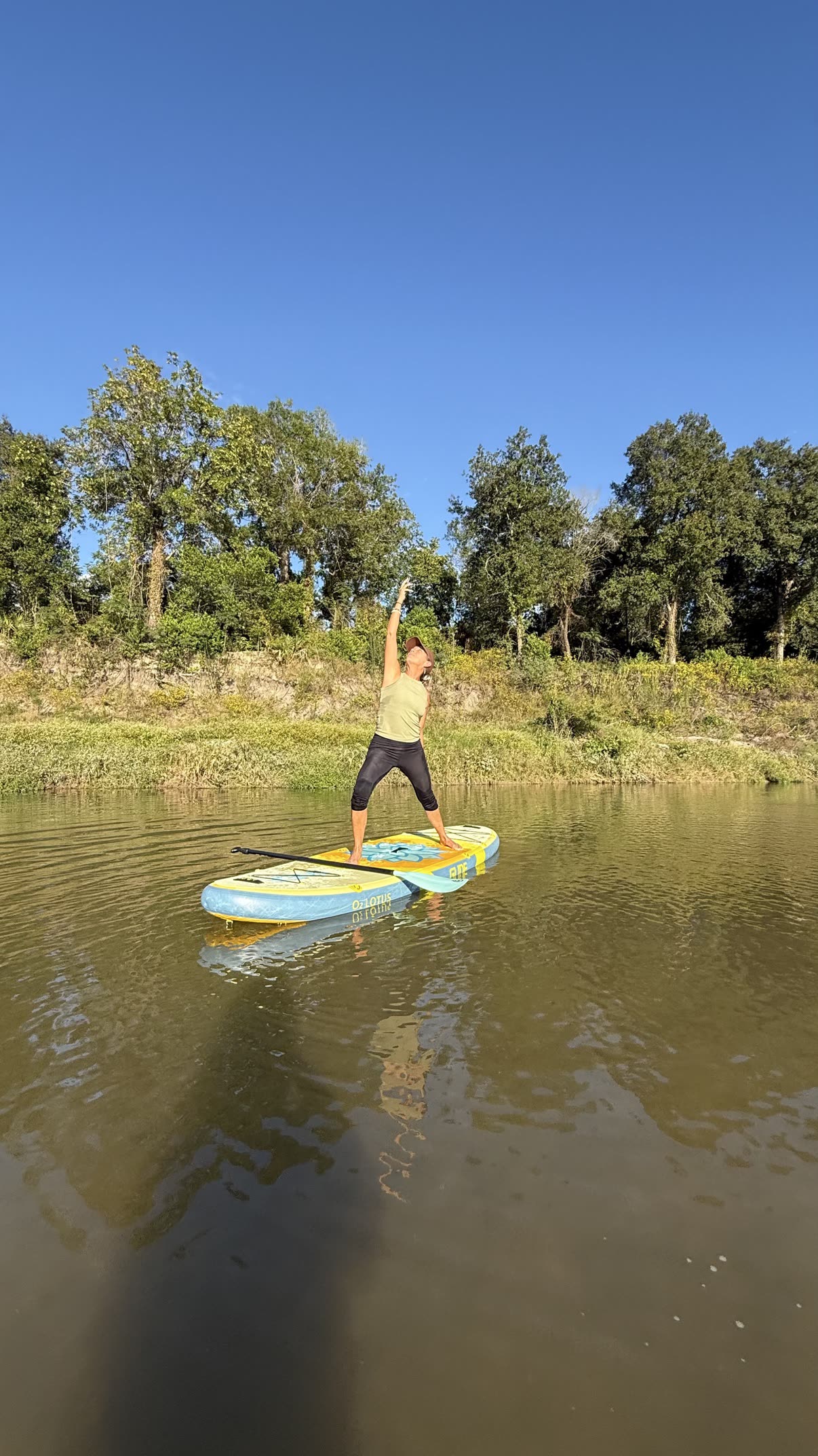 Paddleboard yoga on the river — triangle pose